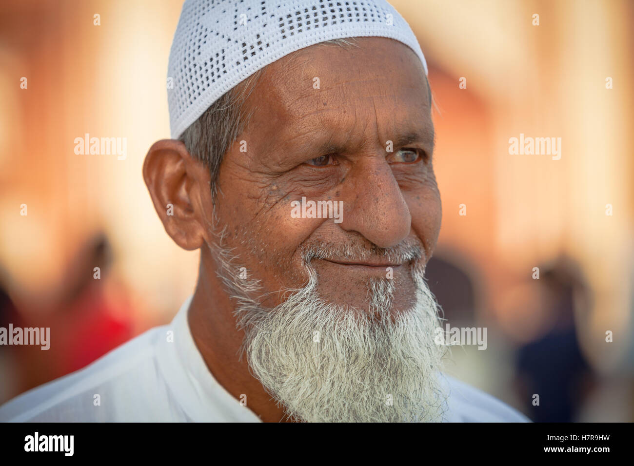An older man wearing the traditional moslem kofi or topi hat, and beard, smiling and friendly-looking Stock Photo