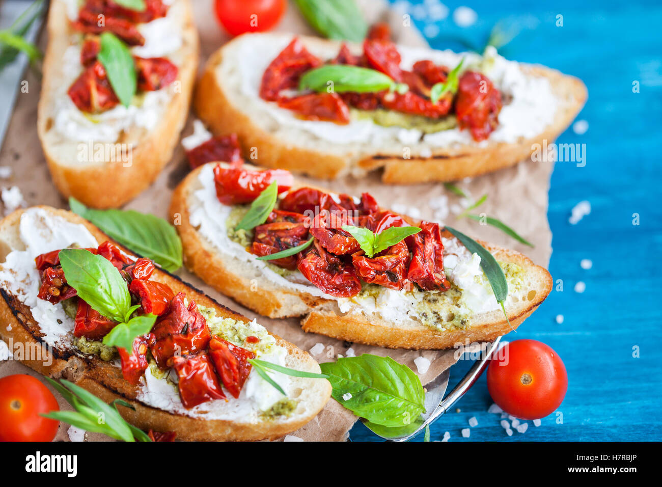 Bruschetta with cream cheese, pesto, fresh basil and sun dried tomatoes