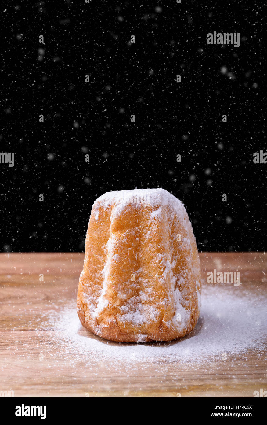 pandoro cake with icing sugar and snow on wood traditional dessert in Italy for christmas Stock Photo