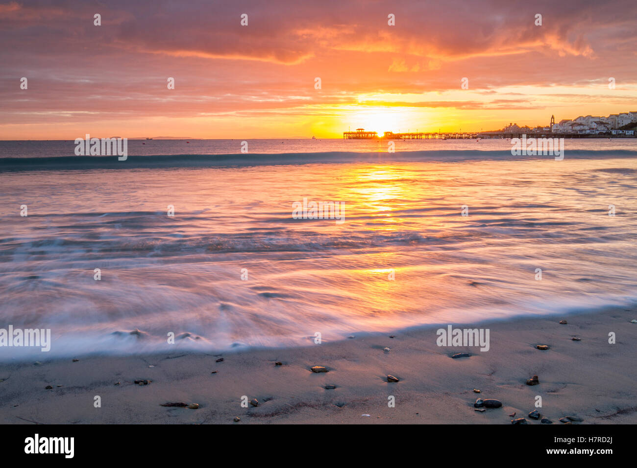 beautiful sun rising over silhouette pier and waves on beach Stock ...
