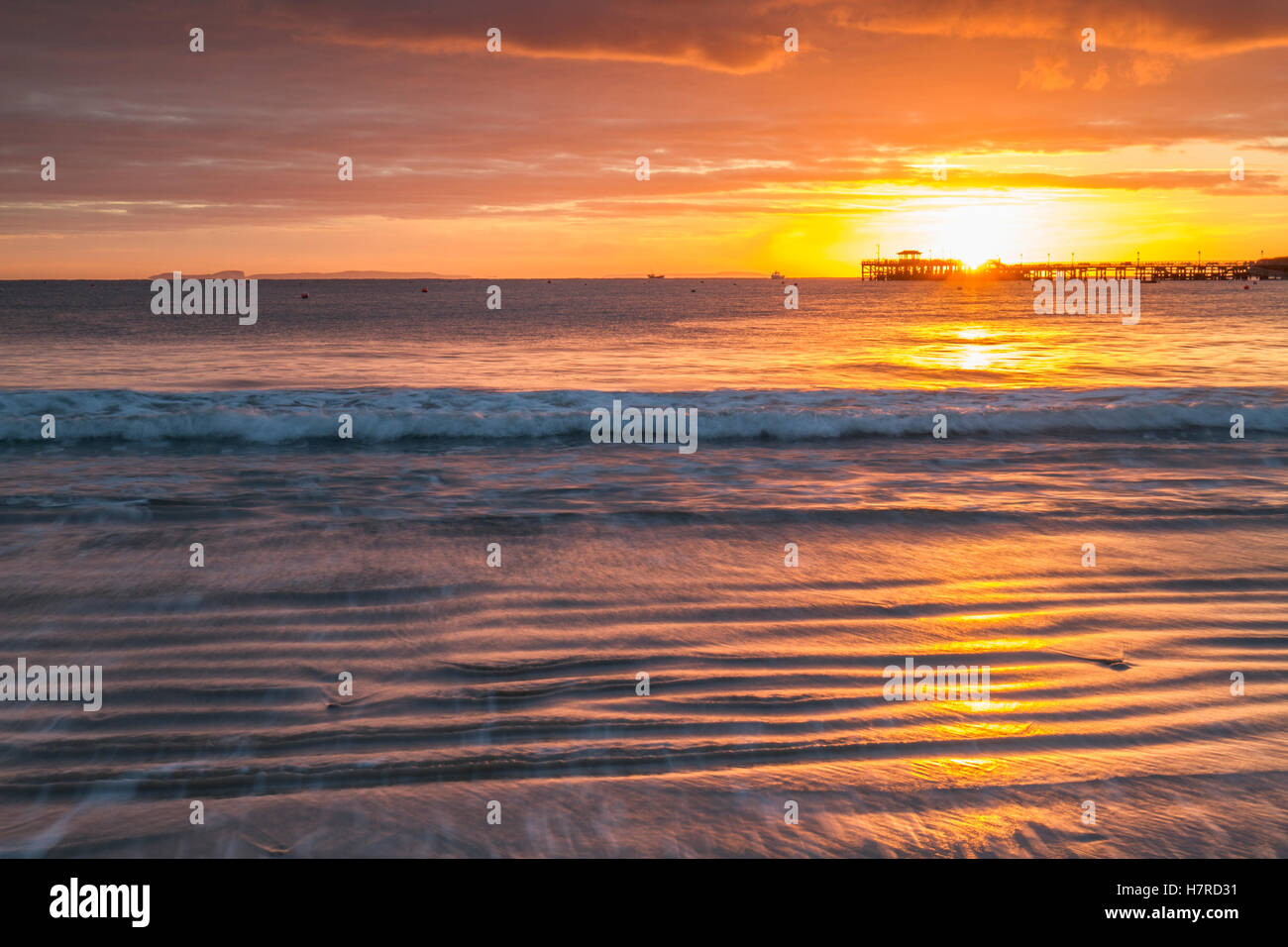 beautiful sun rising over silhouette pier and waves on beach Stock ...
