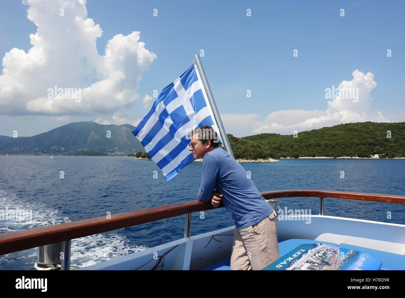 Nidri, GREECE, May 11, 2013 The man and Greek flag on the yacht in