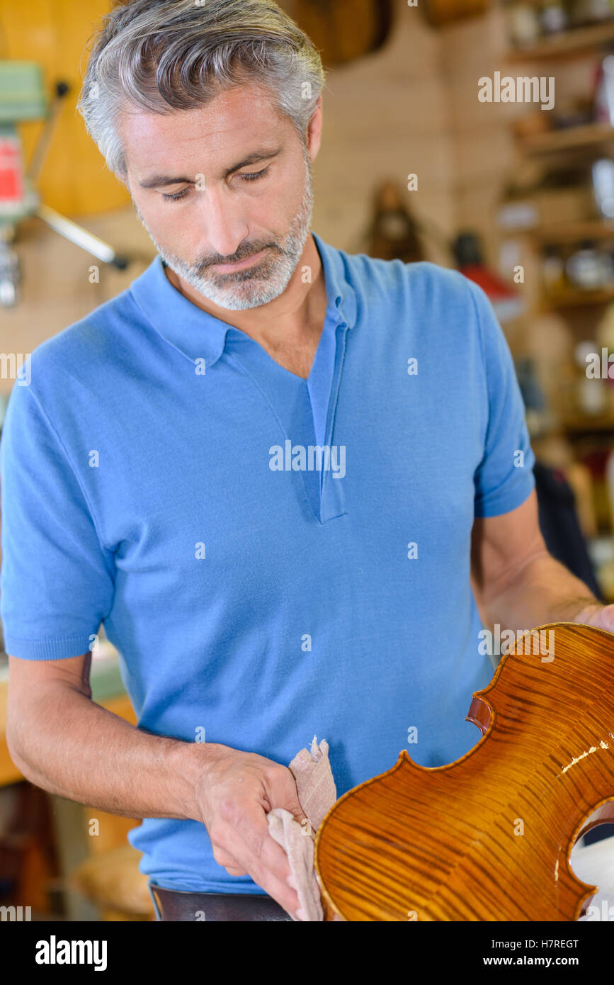 luthier wiping a violin Stock Photo Alamy