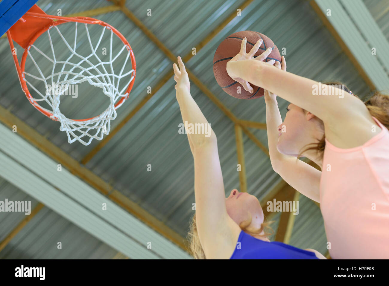 Lady aiming for basketball hoop Stock Photo