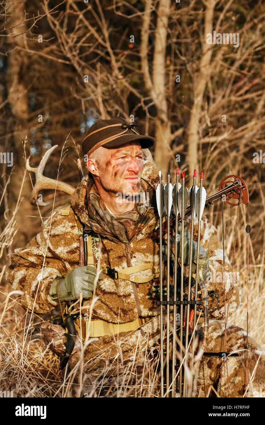 Bowhunter In Camo Clothing hunting Whitetail Deer Stock Photo