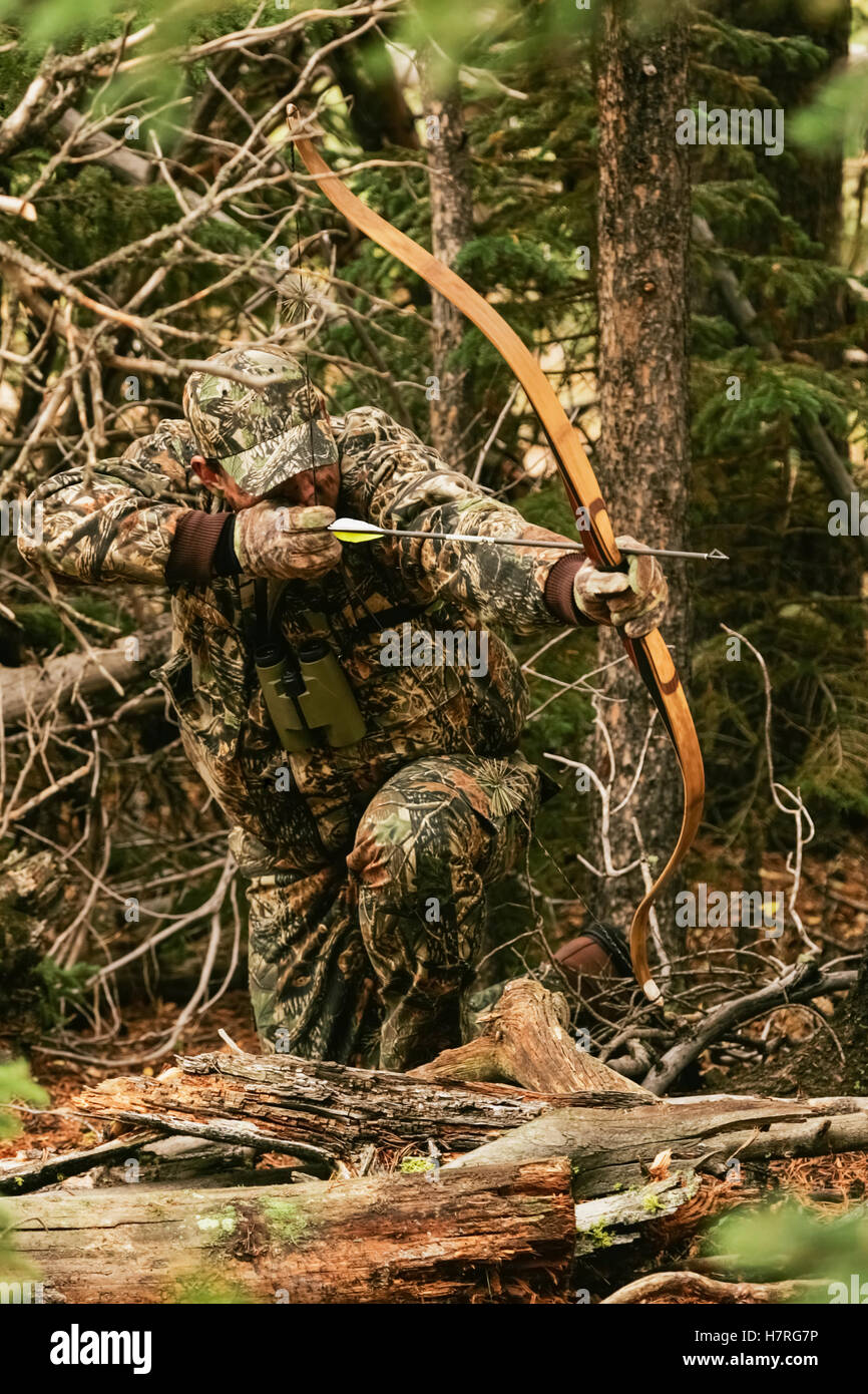 Traditional Bow Hunter With Bow In Woods Stock Photo