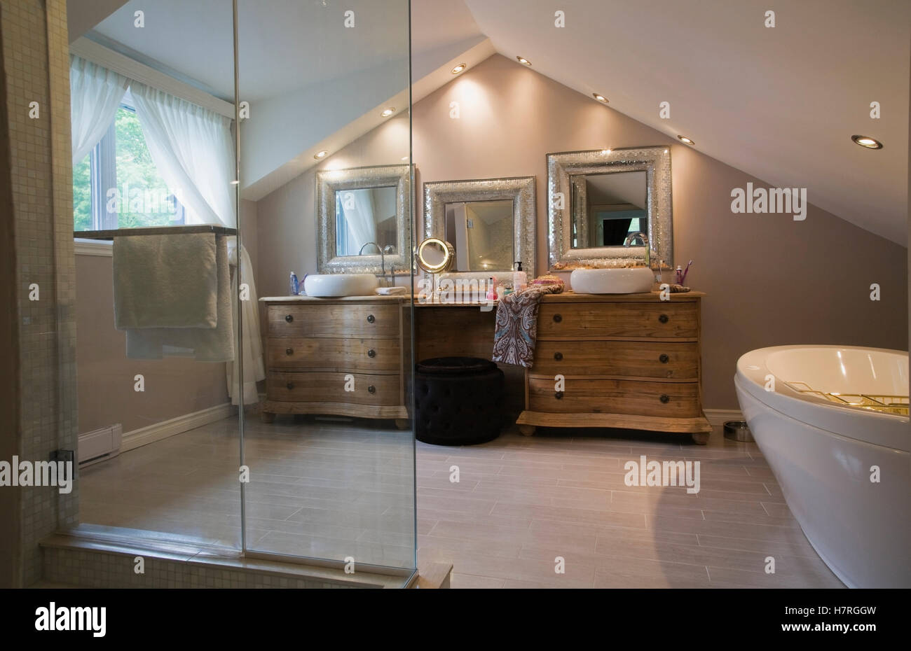 Master Bathroom With Wooden Cabinets And Silver Framed Mirrors