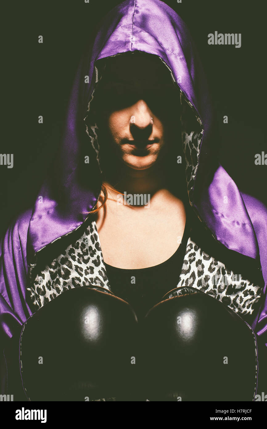 A woman with a purple satin hooded cape over her head, an animal print shirt  and black boxing gloves; Saskatchewan, Canada Stock Photo - Alamy