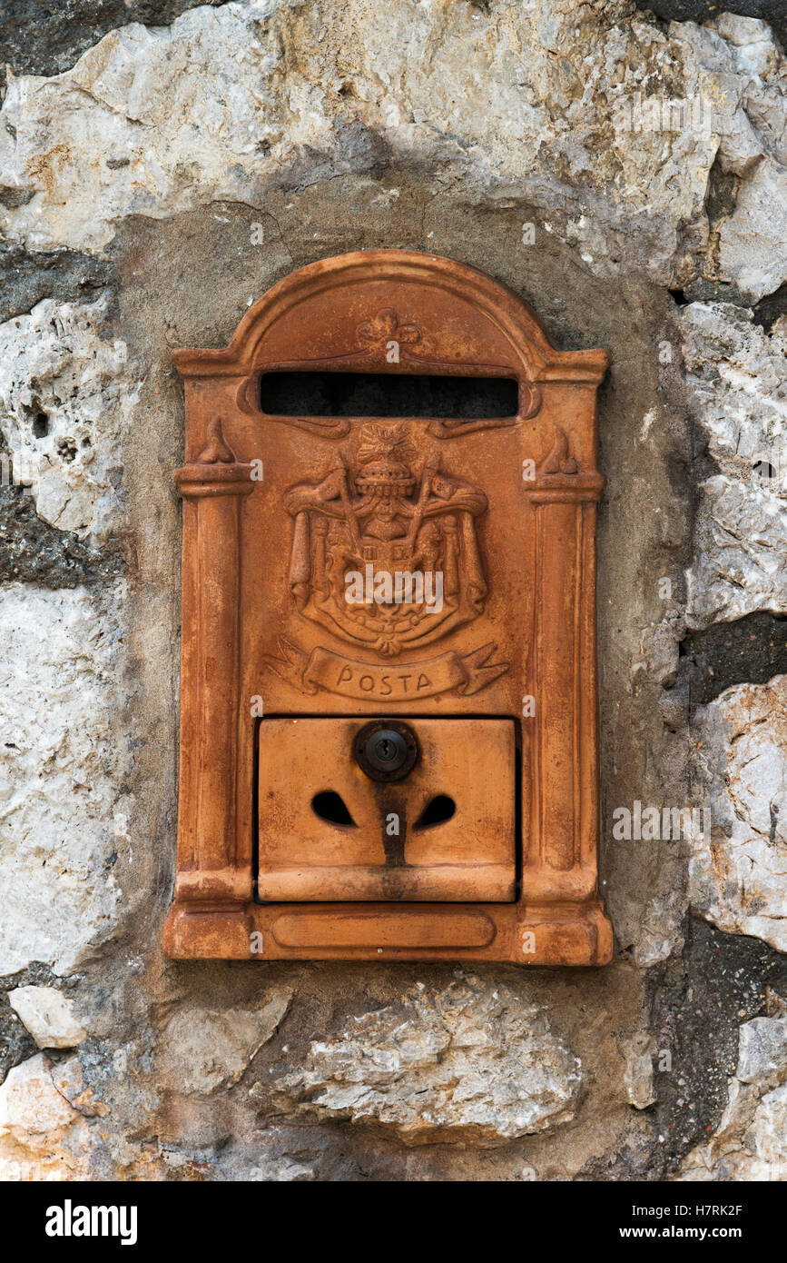 An old mailbox in a weathered stone wall; Capri, Campania, Italy Stock Photo