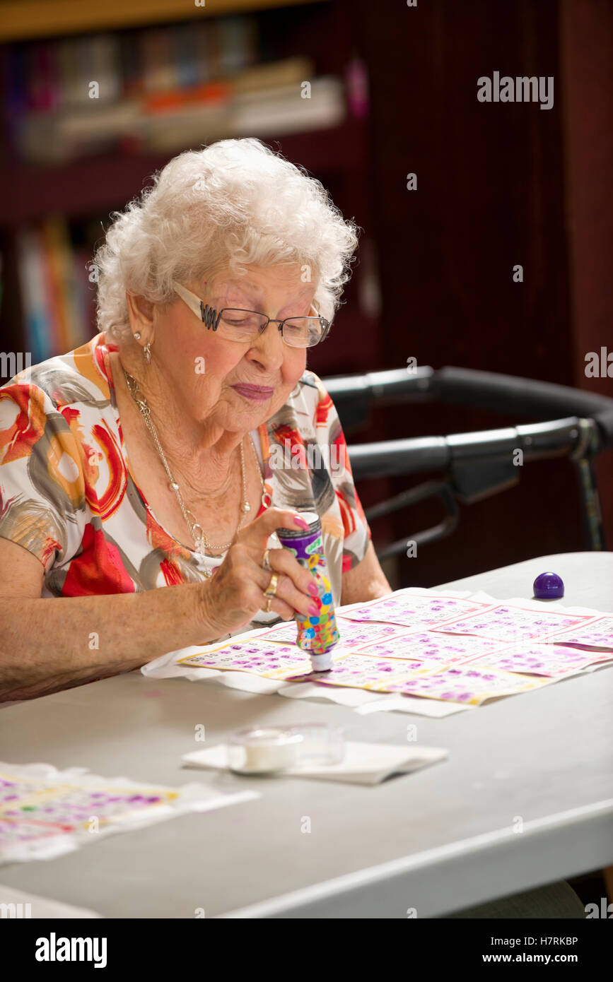 A senior woman playing bingo; Devon, Alberta, Canada Stock Photo