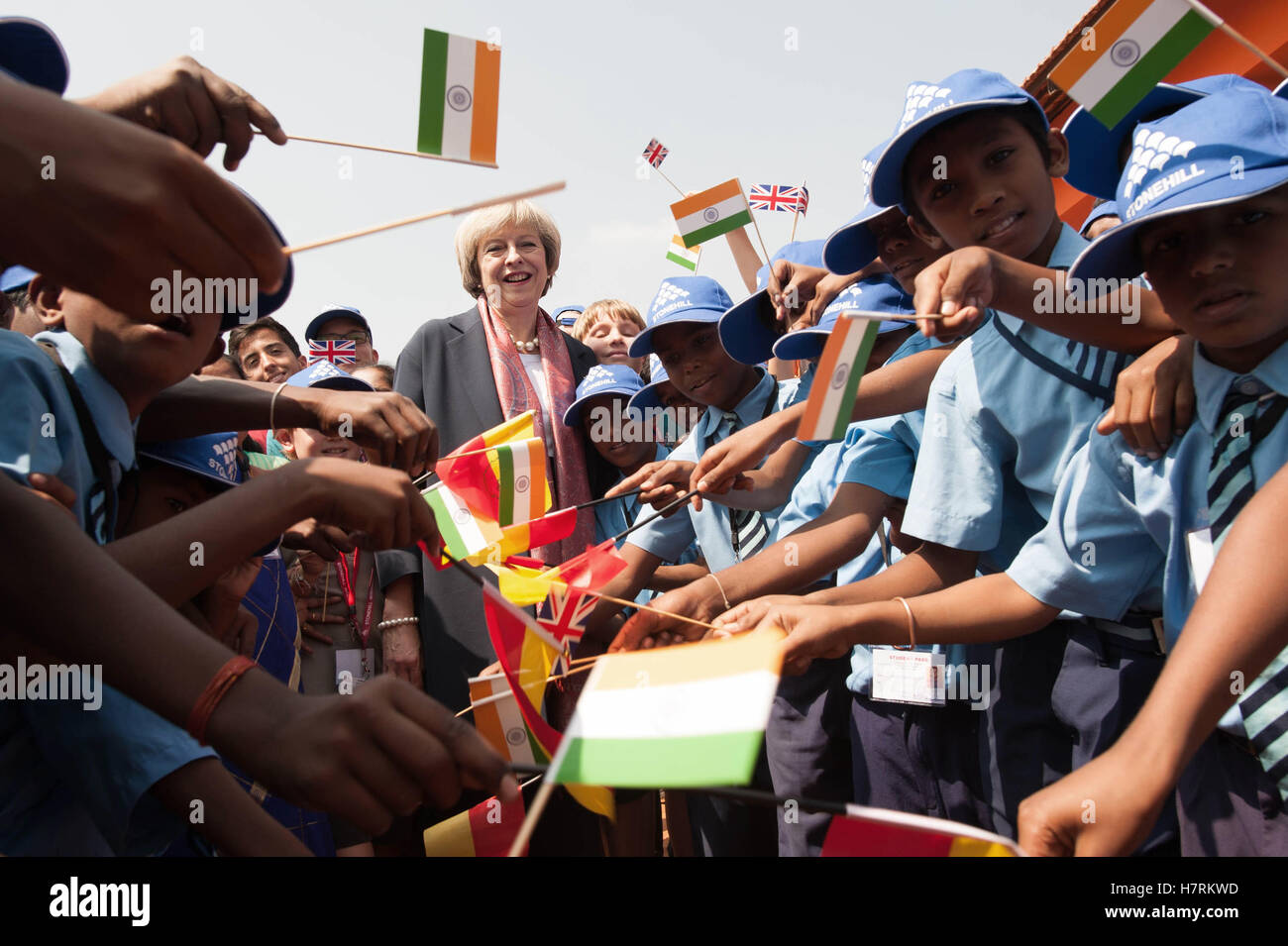 Prime Minister Theresa May watches a flypast by the Indian Air Force with pupils at Stonehill Government Primary School as she arrives in Bangalore on the final day of a three-day trade mission designed to pave the way for close commercial links with the south Asian giant after Brexit. Stock Photo