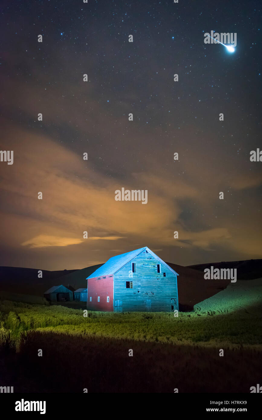Stars and constellations above a farmhouse and barn in a wheat field at night; Palouse, Washington, United States of America Stock Photo