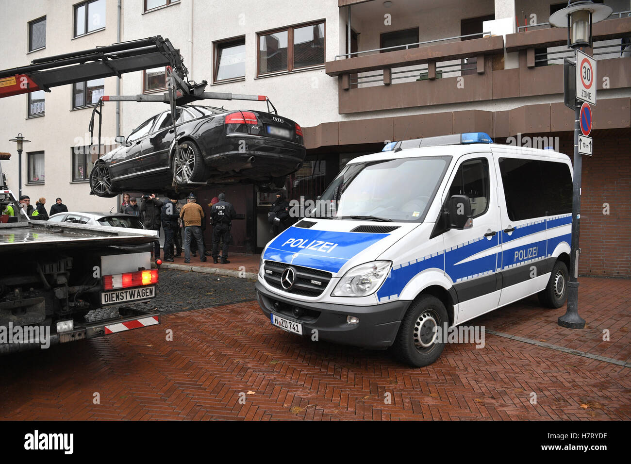 Police officers secure a private vehicle in a residential area in Hildesheim, Germany, 08 November 2016 during an investigation into suspected supporters of the terror group ISIS which resulted in five arrests in two German states on Tuesday morning. Photo: Julian Stratenschulte/dpa (ATTENTION EDITORS: The number plate of the vehicle has been pixelated for legal reasons in order to preserve the anonymity of its owner.) Stock Photo