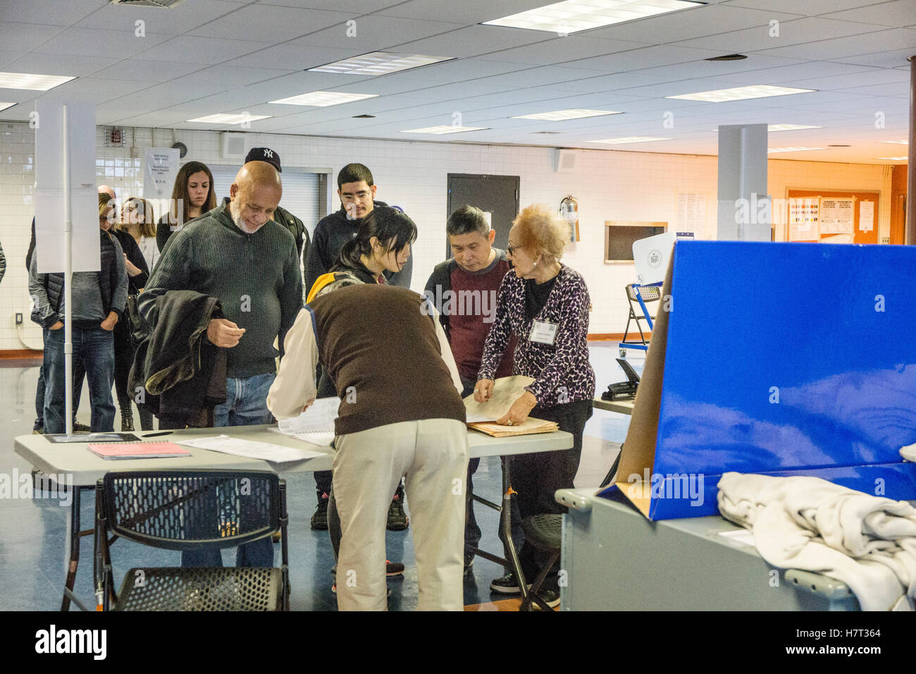 New York, USA. 8th November, 2016. poll workers, including a lady in her 80's assist voters in checking ID & giving instructions on filling out ballots at Park West Vocational High School in Hells Kitchen neighborhood. Park West High School gathers teens from many boroughs to train as cooks. Credit:  Dorothy Alexander/Alamy Live News Stock Photo