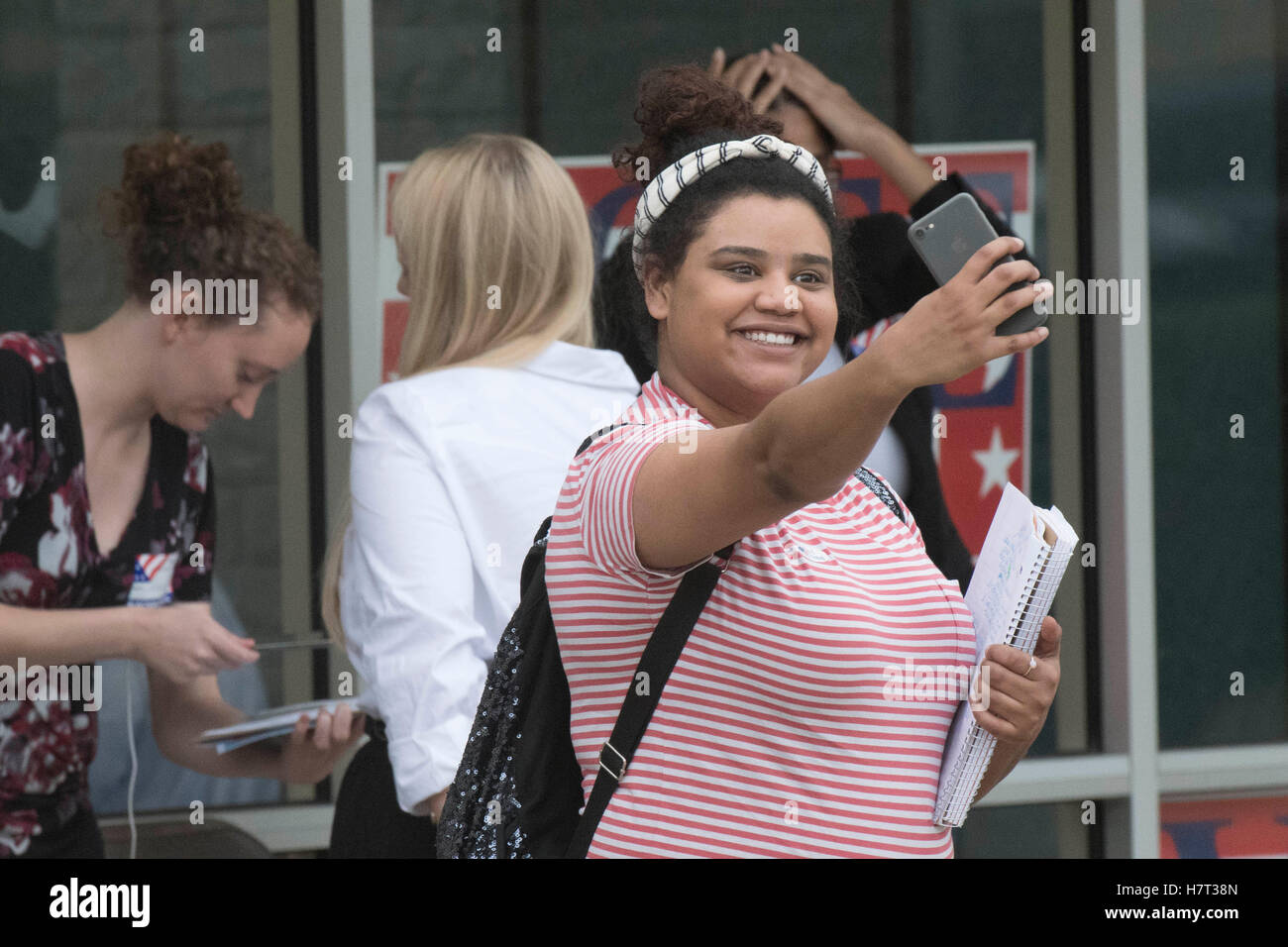 Young voter takes a selfie with her cell phone outside polling place after voting in the 2016 U.S. presidential election. Stock Photo
