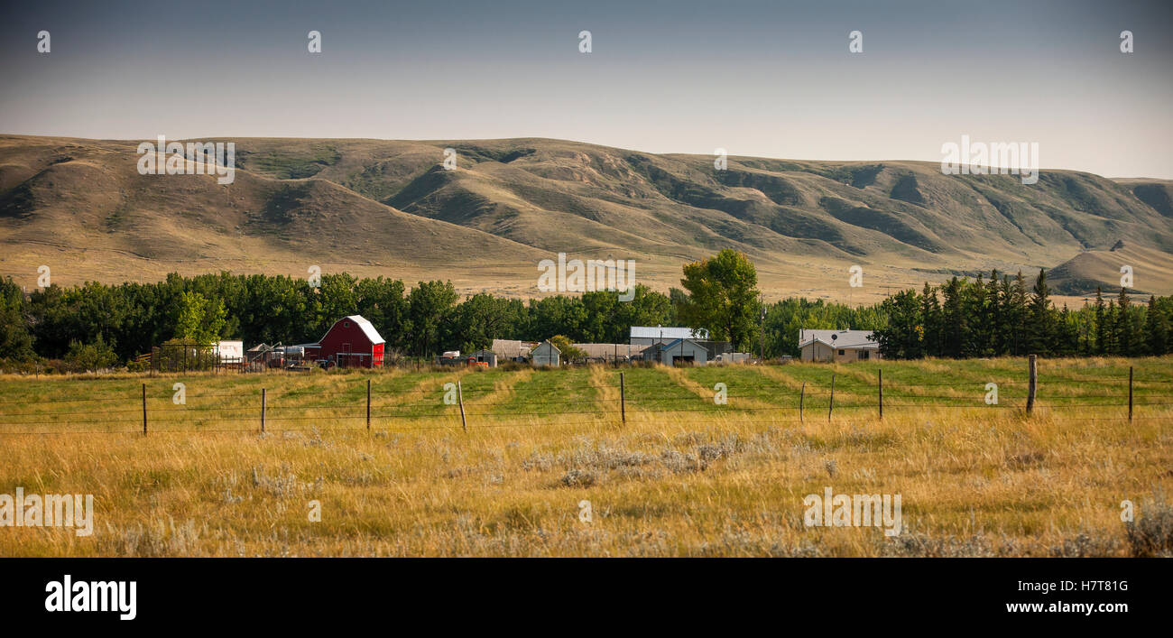 Prairie farms with hills in the background; Saskatchewan, Canada Stock Photo