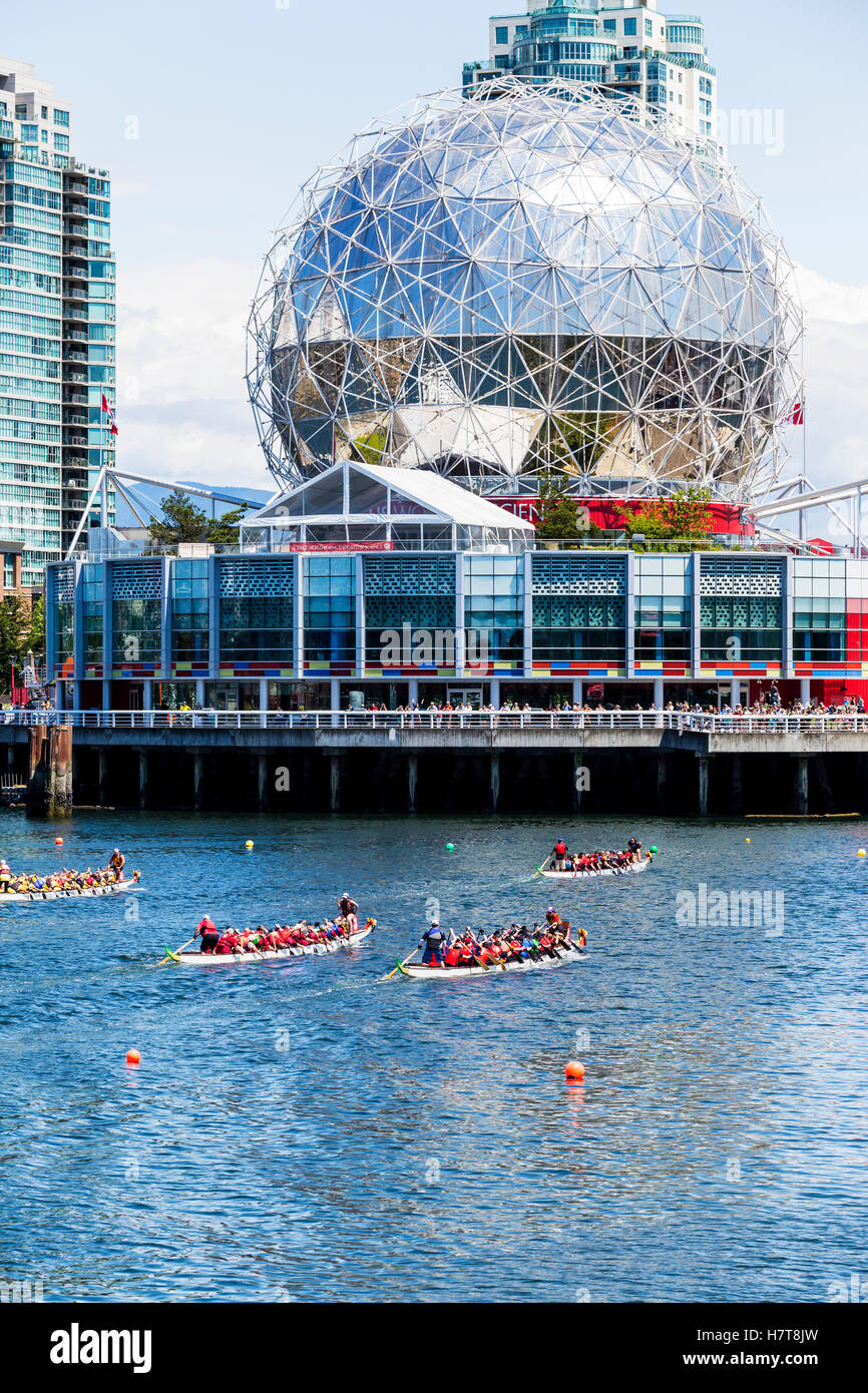 Dragon boats race past Science World on False Creek; Vancouver, British Columbia, Canada Stock Photo