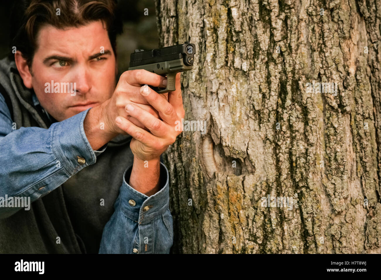 Man drawing gun and pointing handgun at camera Stock Photo Alamy