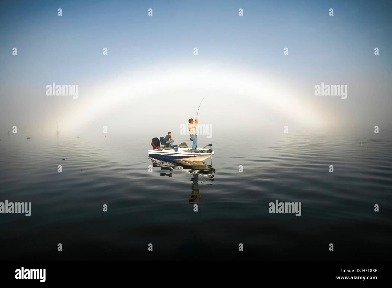 Fisherman In Boat On Water Stock Photo