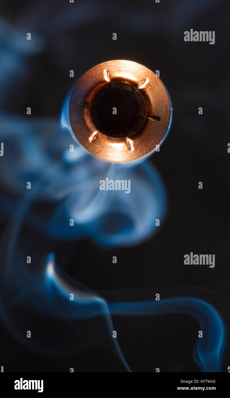 Copper jacketed hollow point direct at the camera with smoke behind