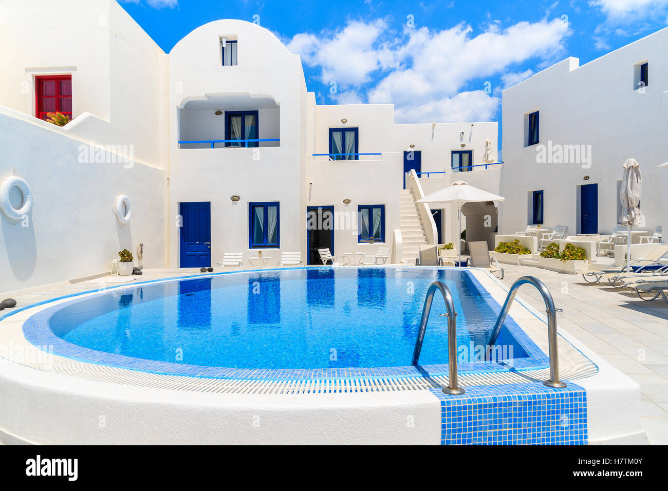 View of typical Greek style apartments with swimming pool in Oia ...
