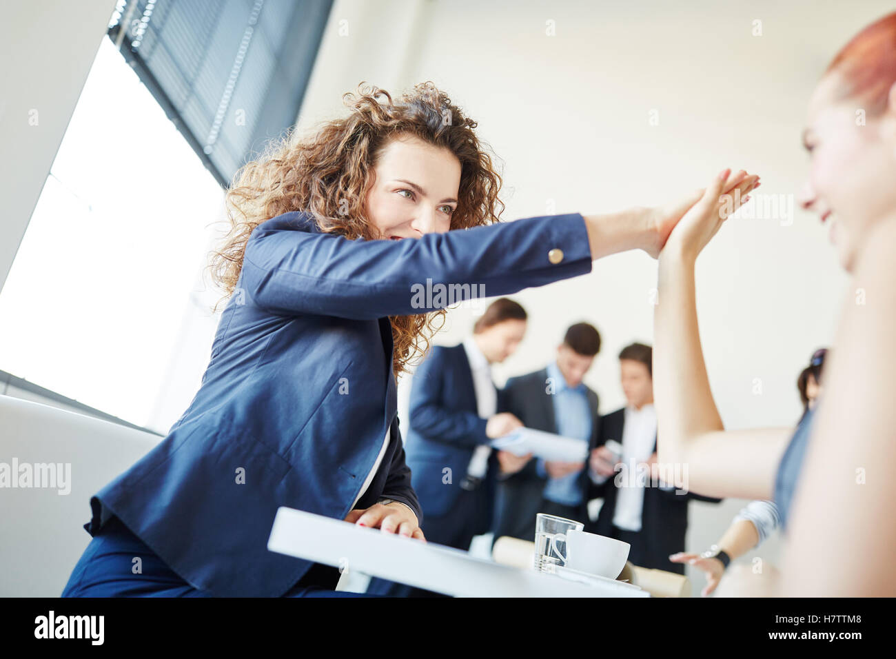 Businesswomen clap each other hands as motivation for success Stock Photo