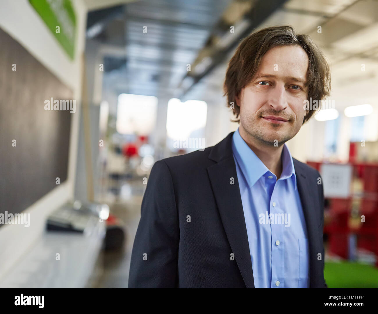 Successful entrepreneur in his start-up looking content Stock Photo
