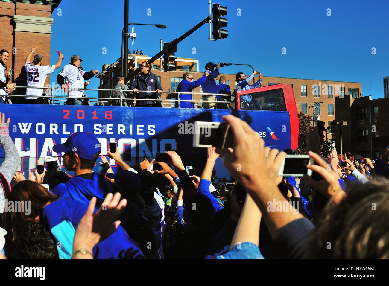 Along the beginning of the parade route near Wrigley Field one of many buses transports Chicago Cubs players toward a rally. Chicago, Illinois, USA. Stock Photo