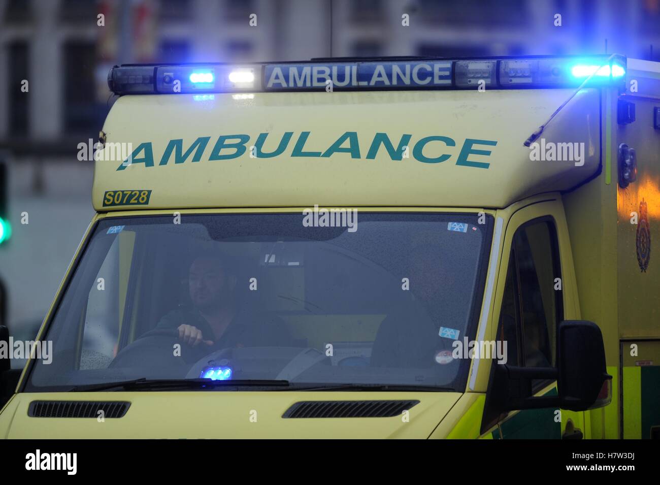 An ambulance with its flashing blue lights on during an emergency. Stock Photo