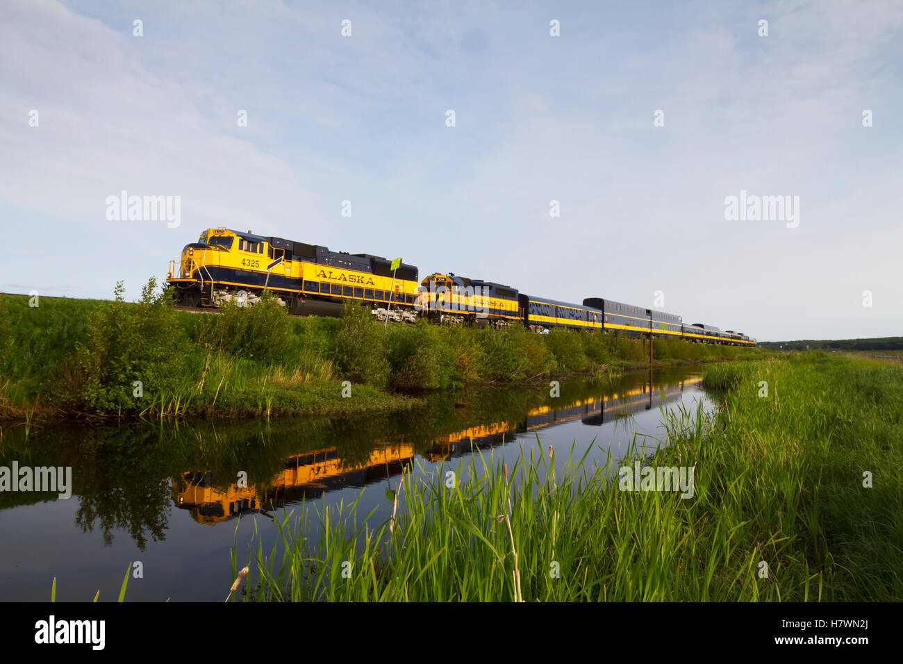 An Alaska Railroad passenger train is reflected in a pond across the Seward Hwy from Potter Marsh. Southcentral Alaska. Stock Photo