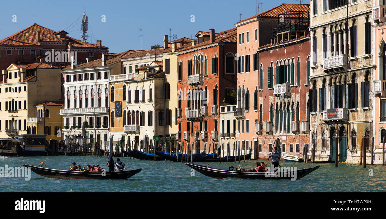 Colourful buildings along a canal with gondoliers in gondolas; Venice, Italy Stock Photo