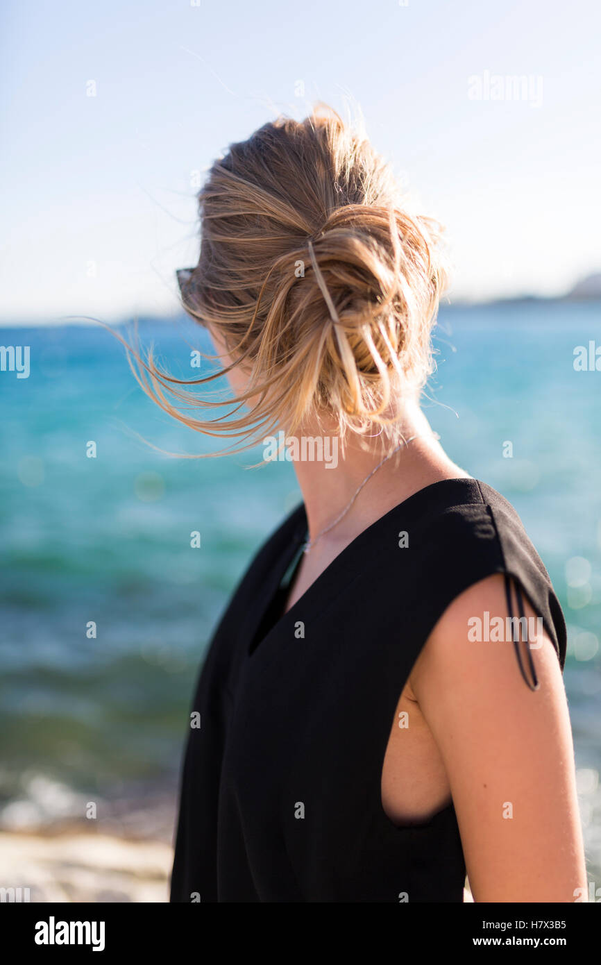 Blonde woman standing by the sea in summer Stock Photo - Alamy