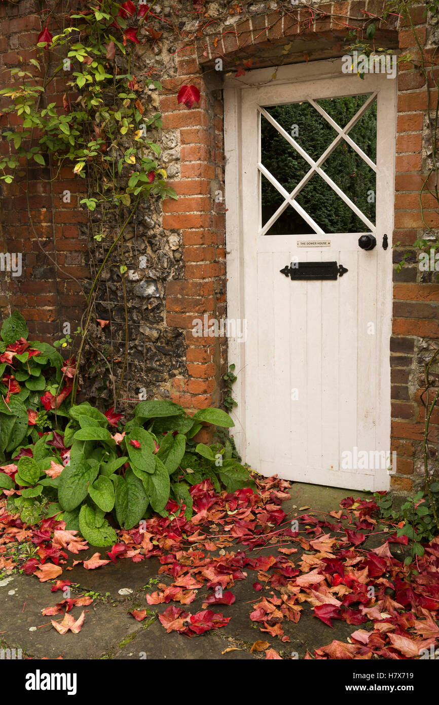 England, Buckinghamshire, West Wycombe, Church Lane, autumnal leaves on ground outside Dower House door Stock Photo
