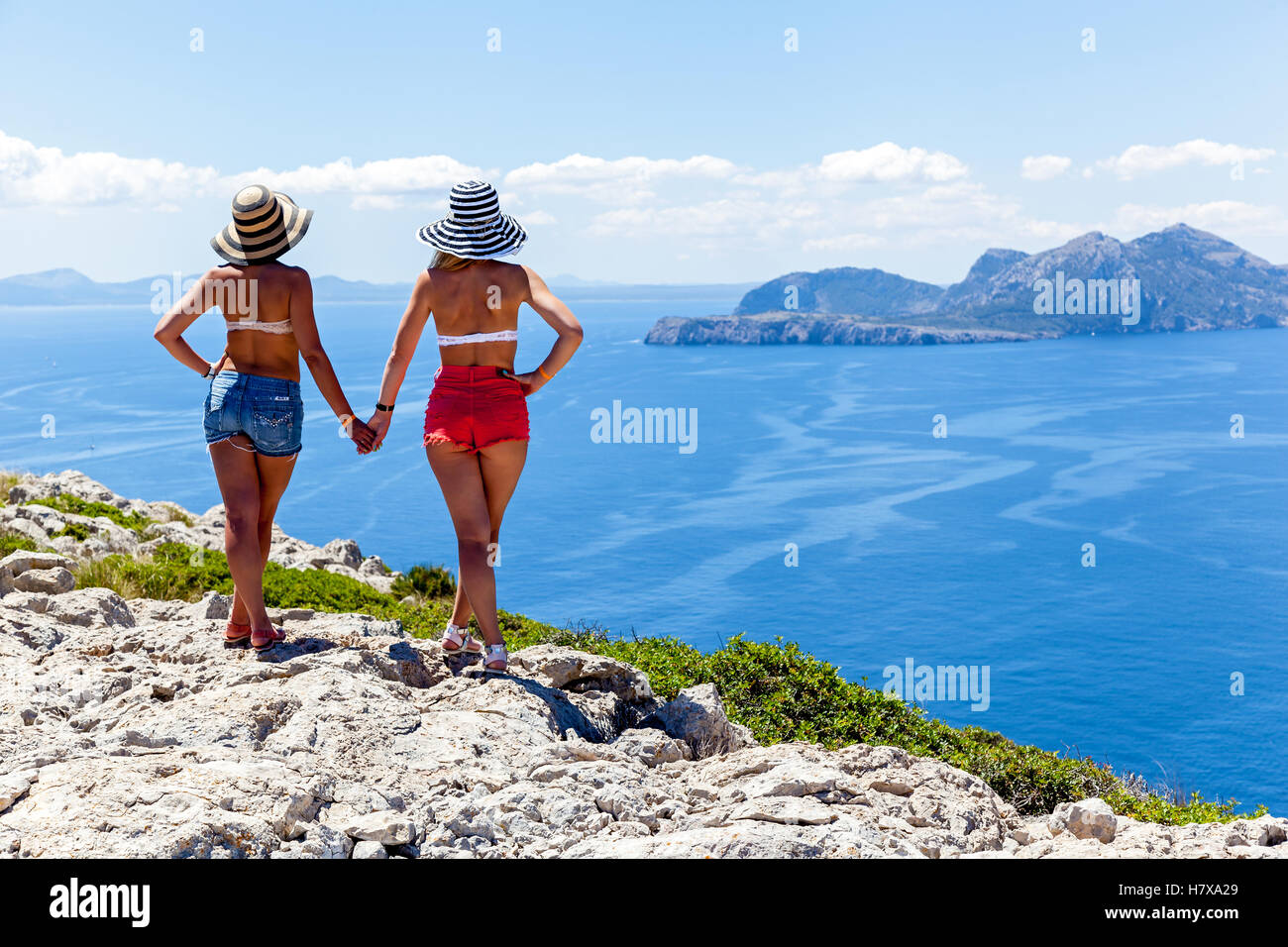 Two girls holding hands watch beautiful seascape,Girls on the edge of ...