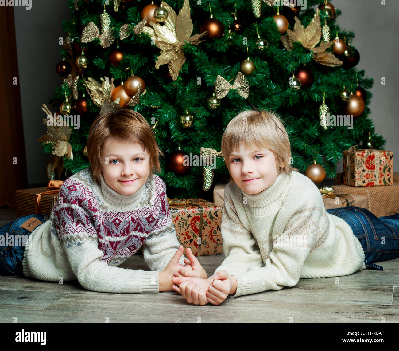 two brothers at home with Christmas tree and presents Stock Photo Alamy