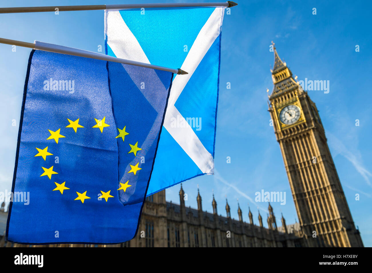 Scottish and EU flags flying in front of Westminster Palace and Big Ben under bright blue sky, London Stock Photo