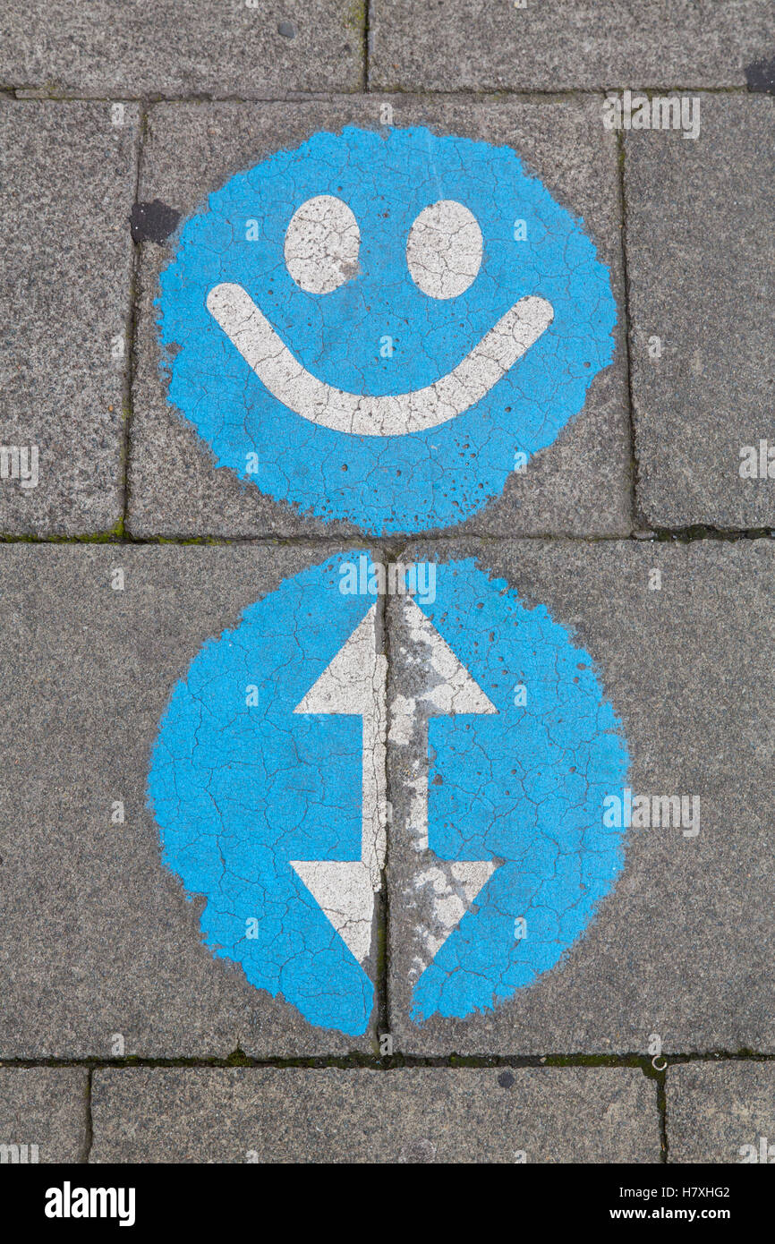 Brussels, Belgium, smiley sign on a sidewalk, is intended to point to a sidewalk with walking in 2 direktions Stock Photo