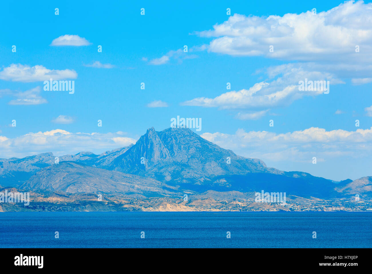 Benidorm city coast summer view and rocks on blue sky (with clouds) background (Costa Blanca, Alicante, Spain). Stock Photo