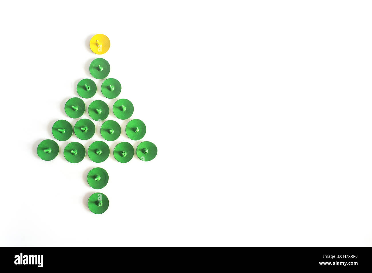 Green push pins. Thumbtacks christmas tree shape isolated on white background. Top view. Close up. Stock Photo