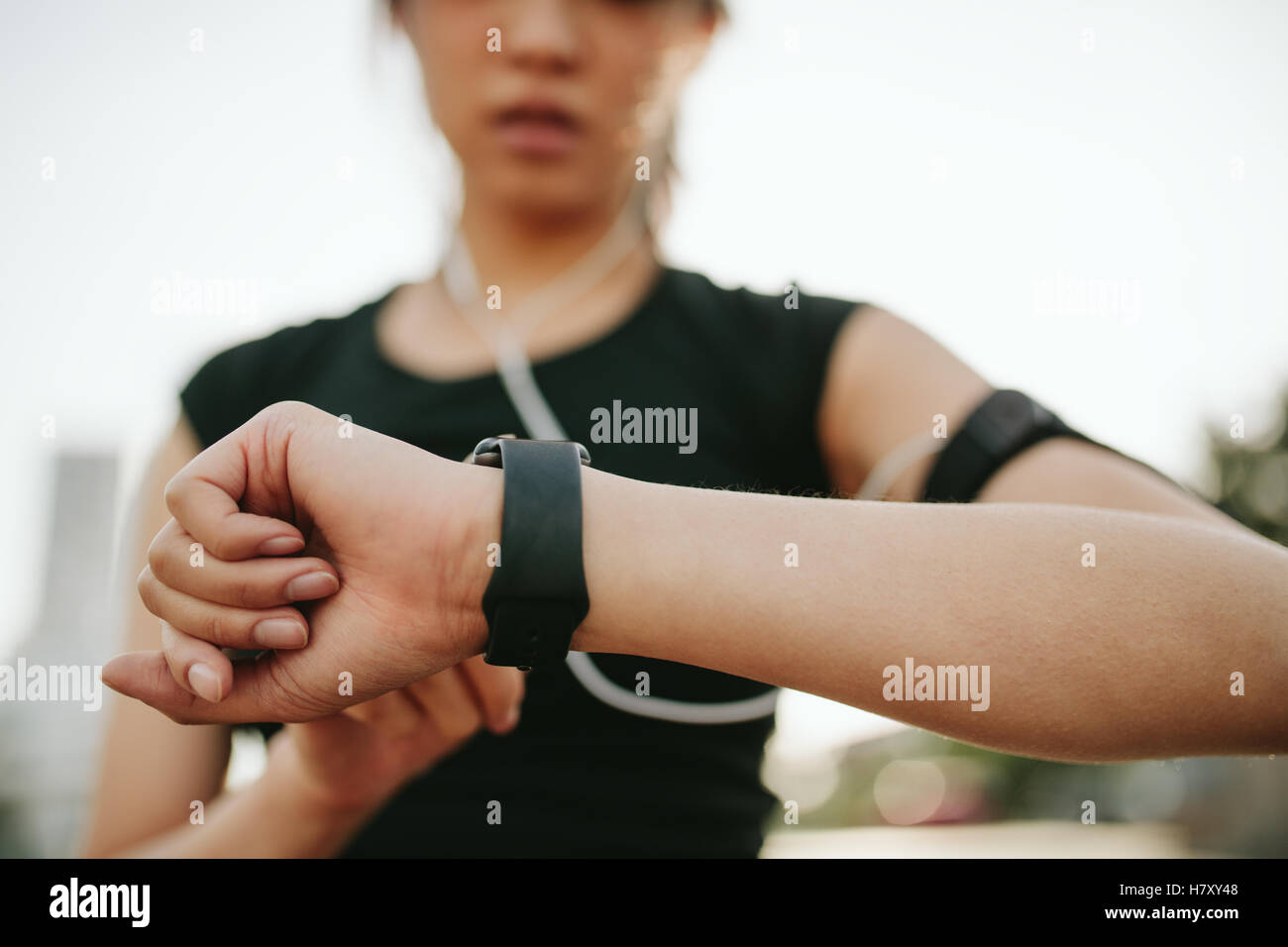 Close up shot of young sportswoman using smartwatch to track her workout performance. fitness female monitoring her progress on Stock Photo