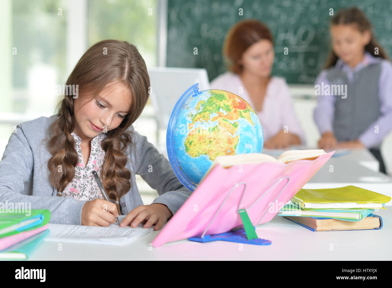 Teacher with two girls at lesson Stock Photo - Alamy