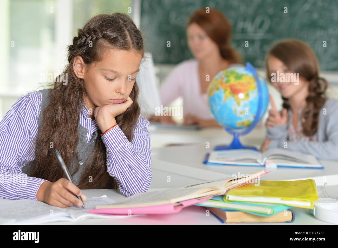 Teacher with two girls at lesson Stock Photo - Alamy