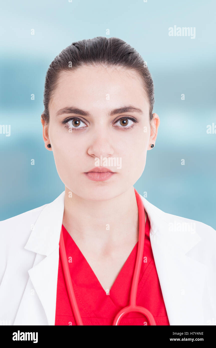 Closeup portrait of serios female doctor with medical uniform and stethoscope isolated on blue background Stock Photo