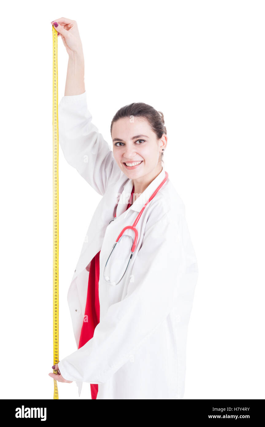 Cheerful woman doctor measuring height with tape meter isolated on white background Stock Photo