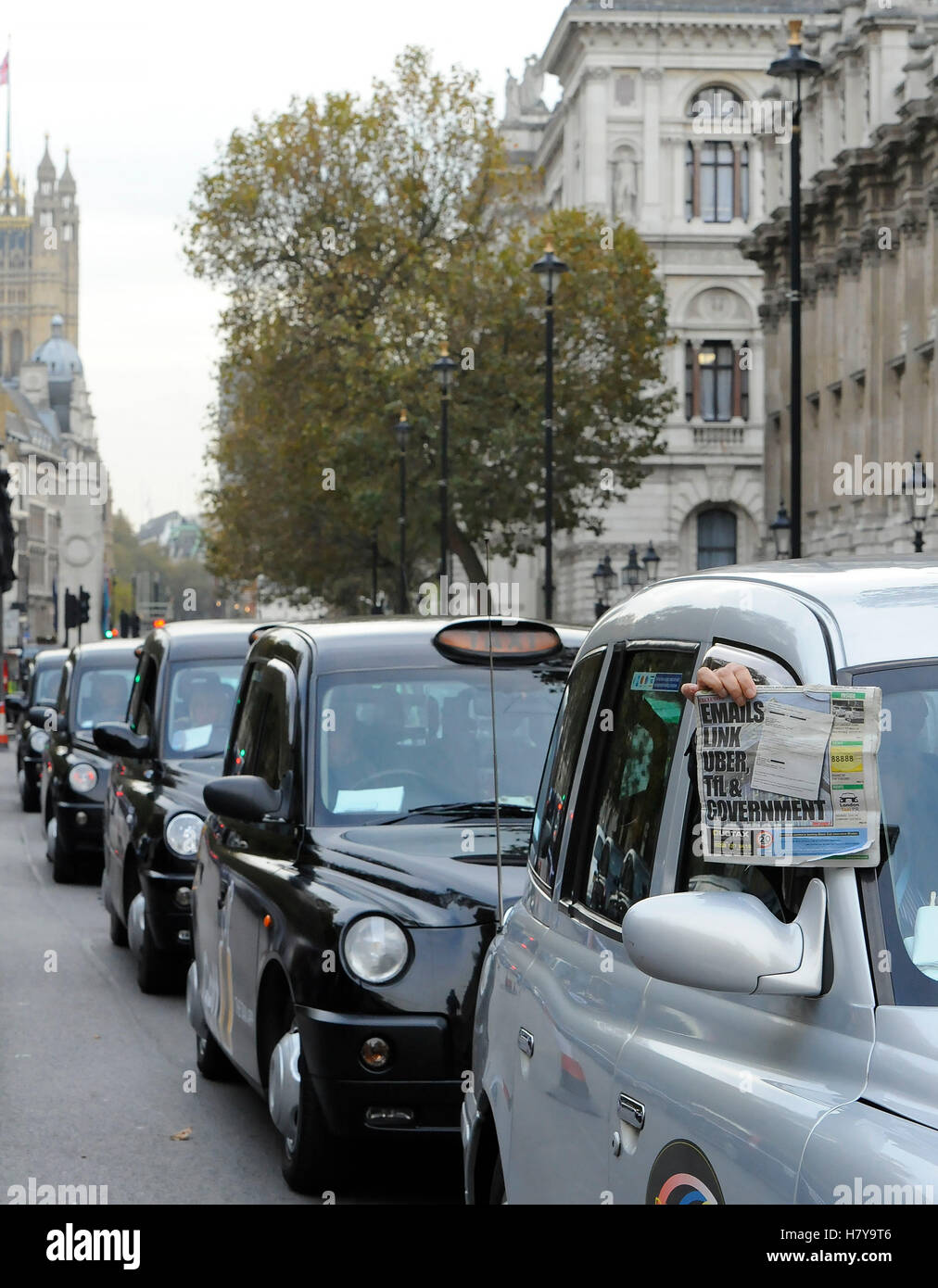 A driver holds up a newspaper, as black cab drivers hold a protest in Whitehall, London, to call for an inquiry into Transport for London (TfL) over congestion and air pollution. Stock Photo