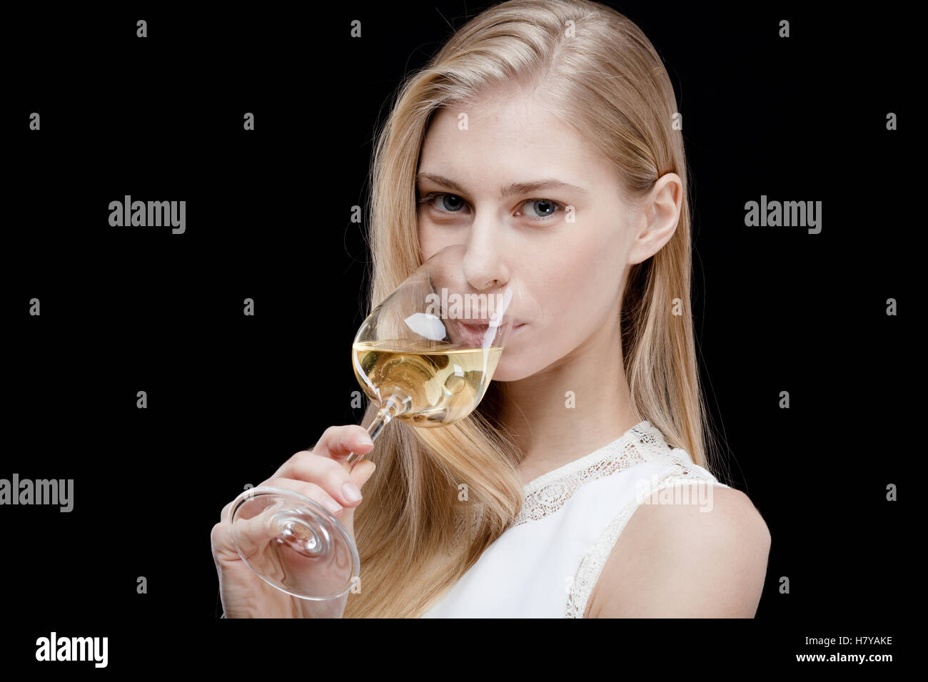 young blond woman holding glass of white wine Stock Photo - Alamy