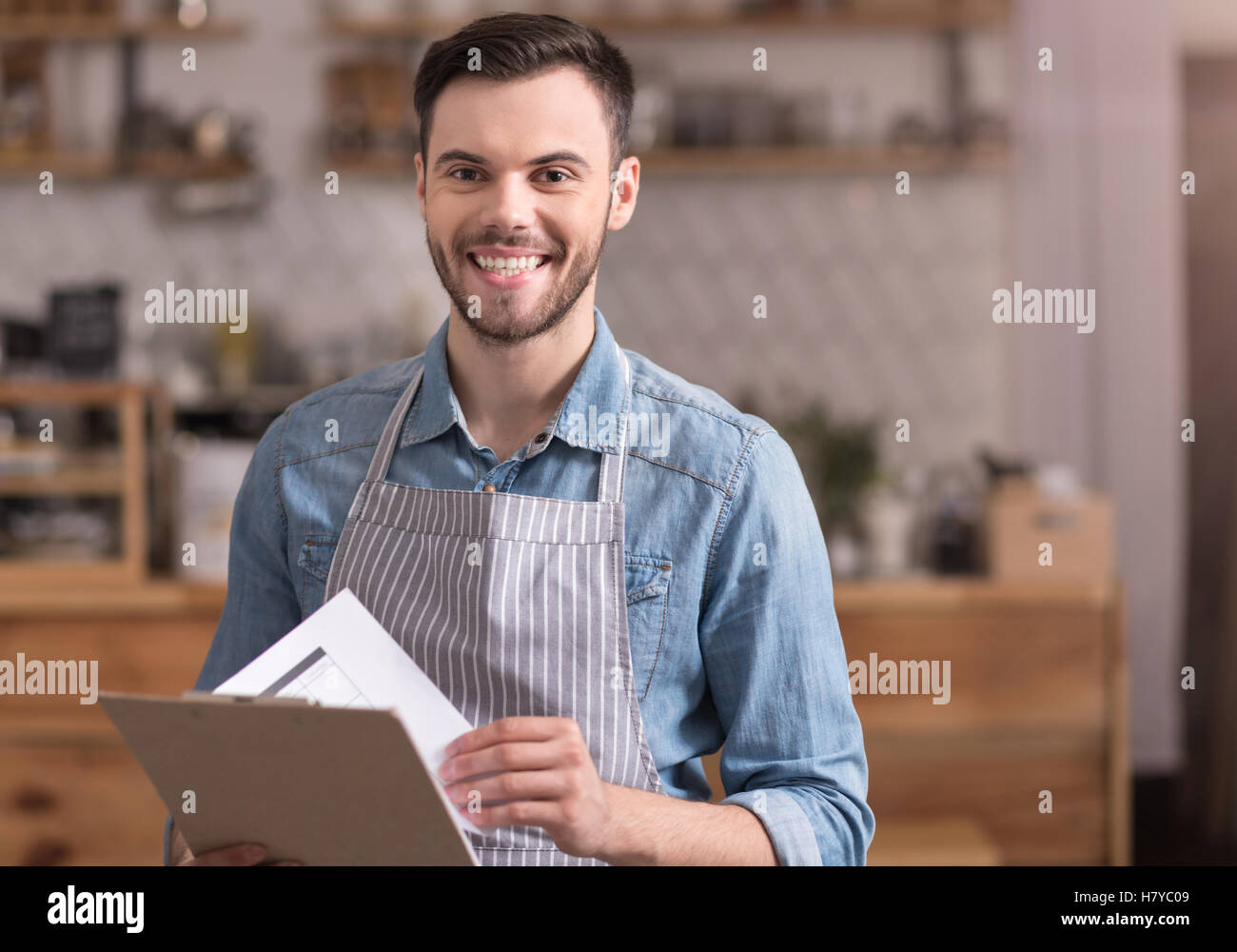 Delighted young smiling man holding a folder. Stock Photo