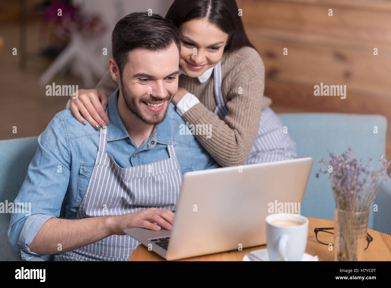 Happy couple smiling and using laptop. Stock Photo