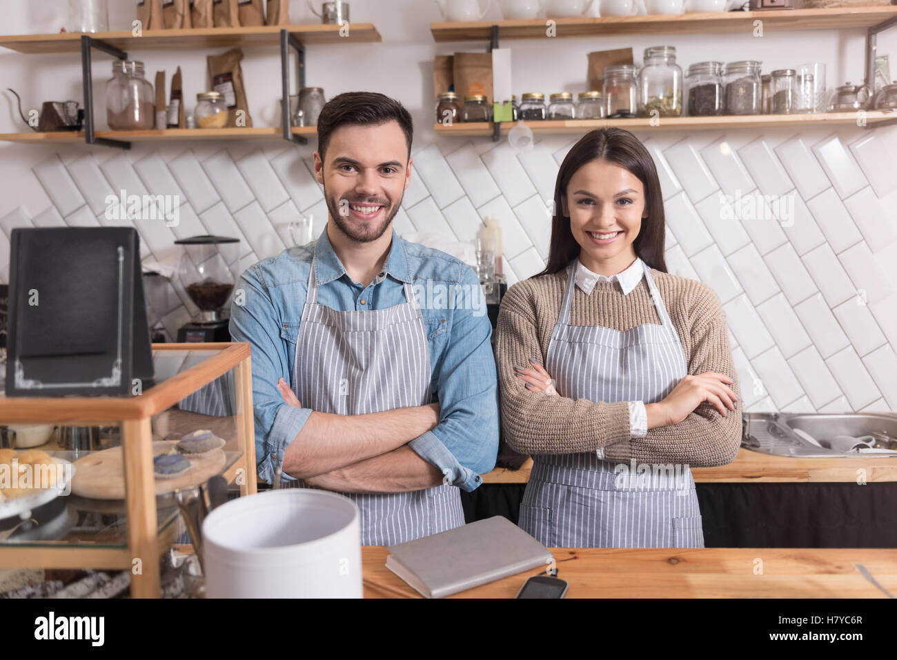 Smiling couple crossing hands while standing behind bar. Stock Photo