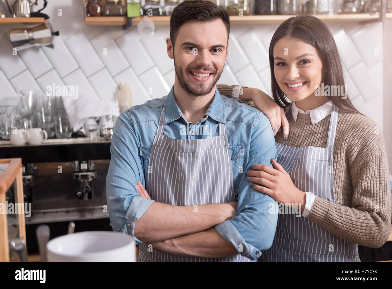 Smiling young couple hugging and standing behind the bar. Stock Photo